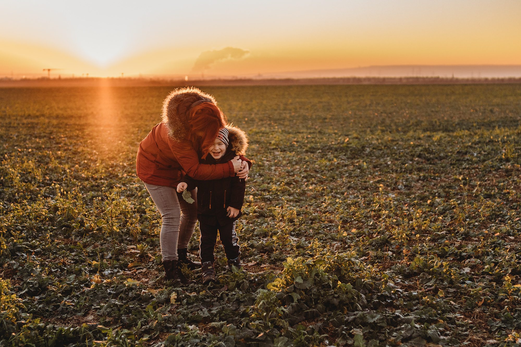 Mutter drückt ihr Kind auf einem Feld in Merzenich