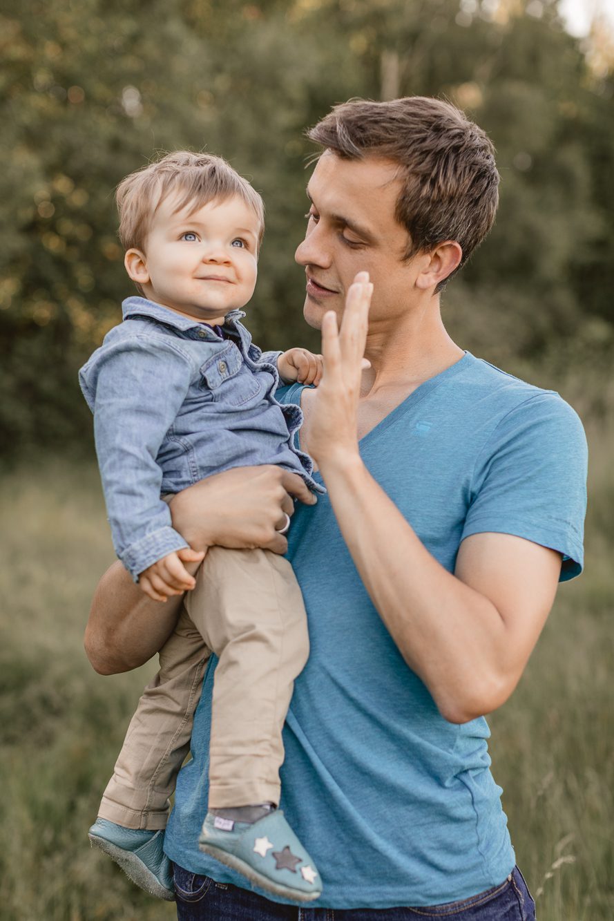 Babie auf dem Arm seines Vaters fotografiert