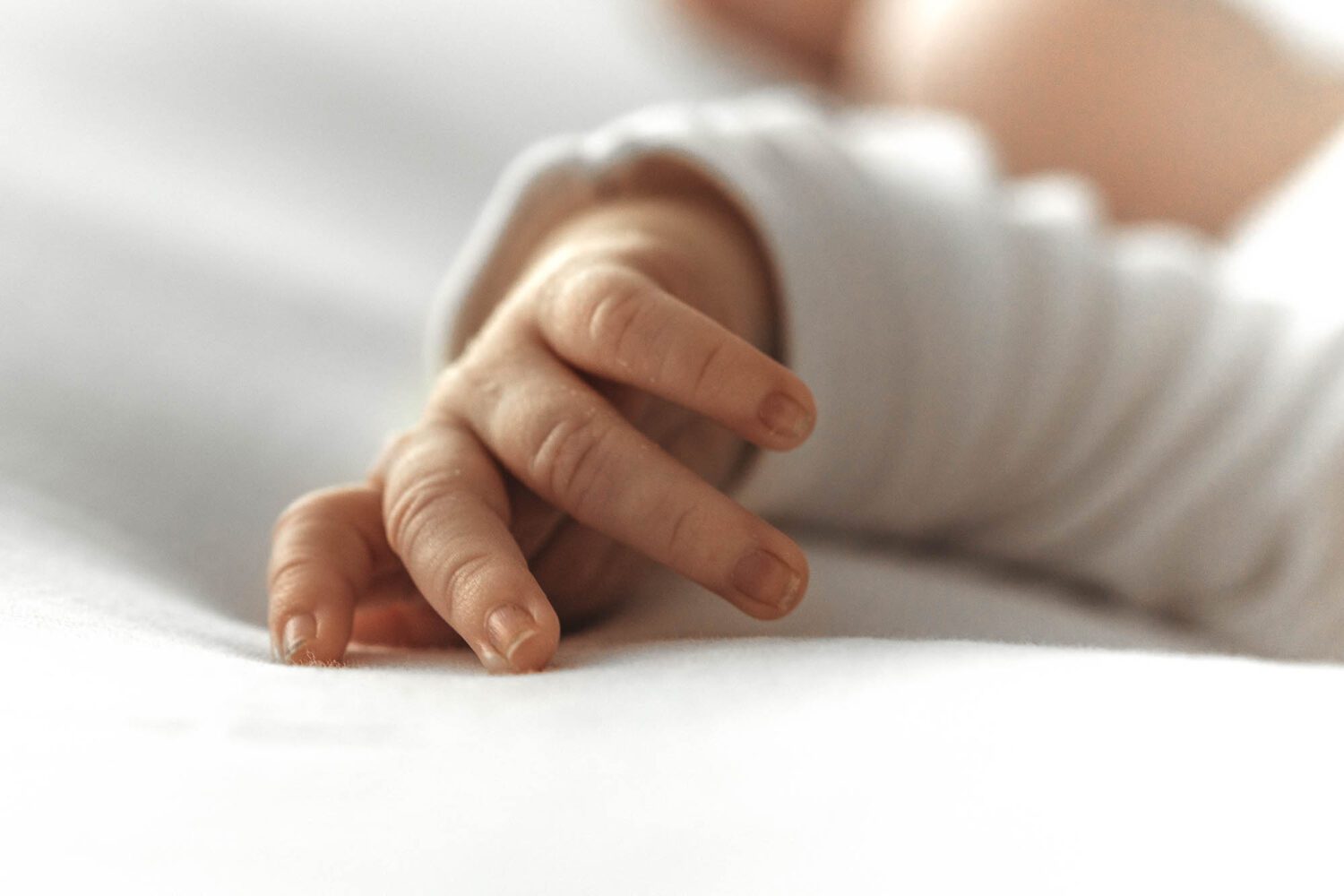 Nahaufnahme von einer Babyhand, man sieht sehr schön die Fingernägel des neugeborenen Babies