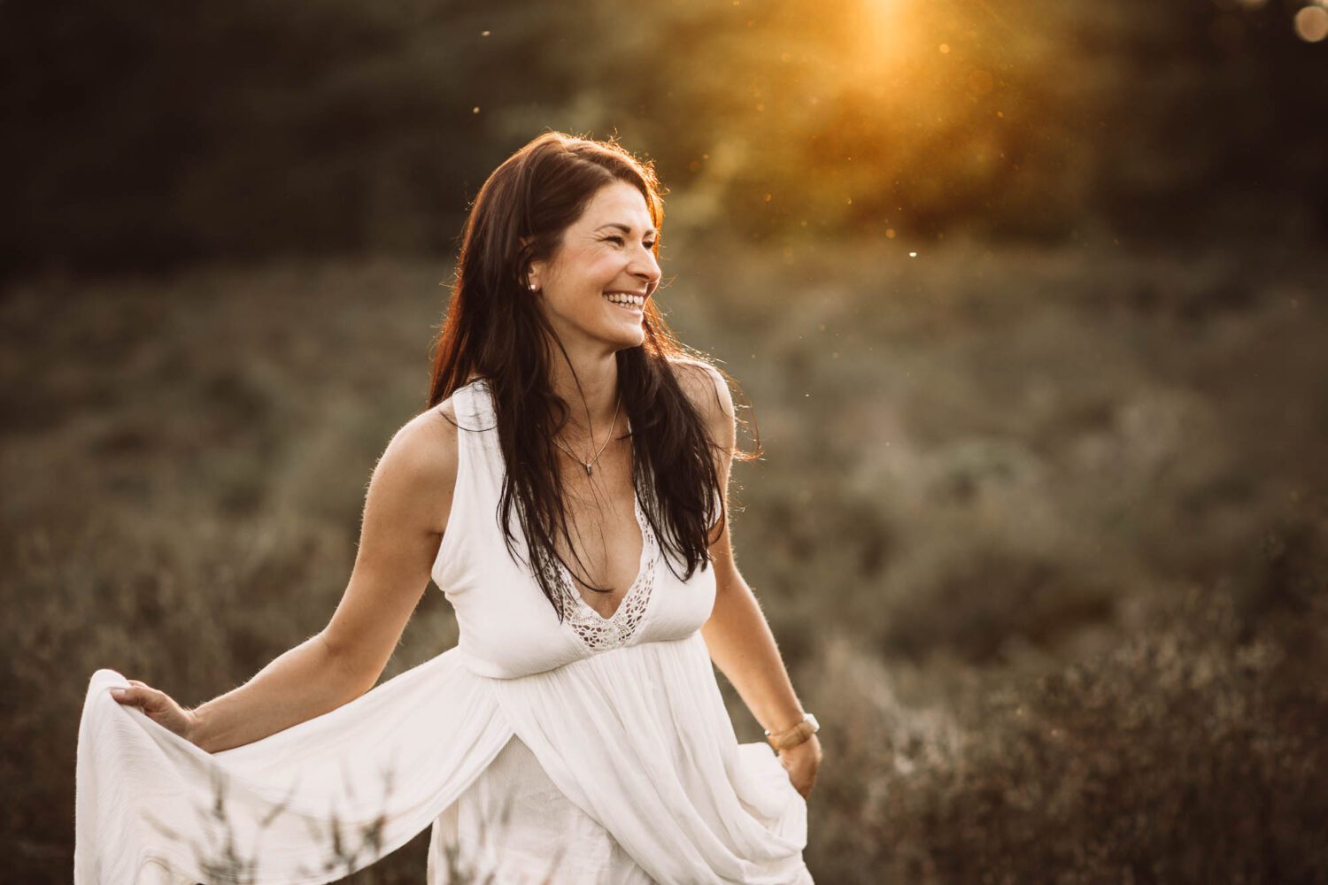 Portrait Aufnahme von einer positiv strahlenden jungen Frau welche richtig herzhaft lacht