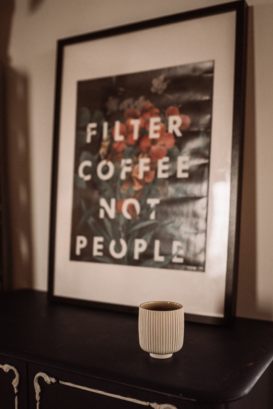 Bilde mit dem Spruch Filter Coffee Not People vor dem eine Keramik Becher steht